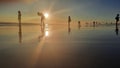 A group of silhouetted people standing in a row on a sand beach Royalty Free Stock Photo