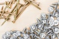 Group of silvery self-tapping screws is arbitrarily positioned on a wooden surface, selective focus, abstract background