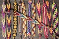 Group of simple handmade homemade natural woven bracelets of friendship on wooden background, rainbow colors, checkered pattern