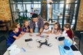 Group of curious school children listen their Korean male teacher uses device of tablet computer for show educational