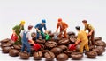 Miniature workers digging through a circle of coffee beans to uncover hidden treasures Royalty Free Stock Photo