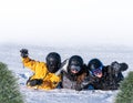 A group of skiers lie on the snow and wave .Winter background with copy space.