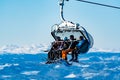 Group of skiers riding a ski lift to the top of a mountain at a ski resort