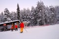Group, skiers and snowboarders on skis at foot of snowy mountain, preparation for ascent from slope in Levi ski resort, tourism,