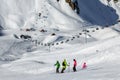 A group of skiers standing on a ski slope in a mountain cirque on a sunny day on the chair lifts background