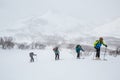 Group skiing uphill in snowstorm in the backcountry of Hokkaido, Japan