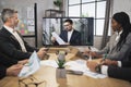 Group of skillful multiethnical businesspeople looking at screen, having video conference Royalty Free Stock Photo