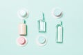 Group of small bottles for travelling on blue background. Copy space for your ideas. Flat lay composition of cosmetic products.