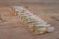 Group of small glass bottles on wooden background. Perfume testers or chemical samples