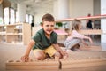 Group of small nursery school children playing indoors in classroom, montessori learning.