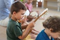 Group of small nursery school children sitting on floor indoors in classroom, playing musical instruments. Royalty Free Stock Photo