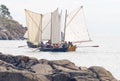 Group of small, old sailing ships vlose to the rocks