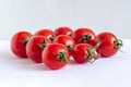 Group of small red cherry tomatoes with green dried cuttings, on white Royalty Free Stock Photo