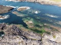 A group of small rocky islands in the clear blue sea, surrounded by foamy waves, on a sunny day Royalty Free Stock Photo