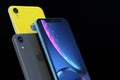 Product shot of iPhone XR blue and yellow on black background