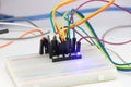 Group of SMD led on a breadboard connected with jumper wires and emitting a blue light