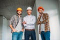 group of smiling architects inside of constructing building looking Royalty Free Stock Photo