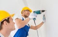 Group of smiling builders with drill indoors Royalty Free Stock Photo