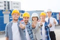 Group of smiling builders in hardhats outdoors