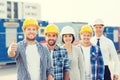 Group of smiling builders in hardhats outdoors