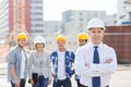 Group of smiling builders in hardhats outdoors