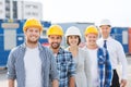 Group of smiling builders in hardhats outdoors