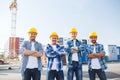 Group of smiling builders in hardhats outdoors