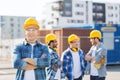 Group of smiling builders in hardhats outdoors