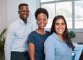 Group of smiling business people pose arms folded in office, diverse trio