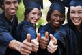 Get educated. A group of smiling college graduates giving the thumbs up at graduation. Royalty Free Stock Photo