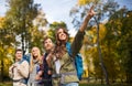 Group of smiling friends with backpacks hiking