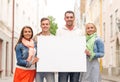 Group of smiling friends with blank white board Royalty Free Stock Photo