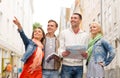 Group of smiling friends with city guide and map Royalty Free Stock Photo