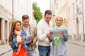 Group of smiling friends with city guide and map Royalty Free Stock Photo