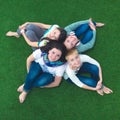 Group of smiling friends lying on grass in circle Royalty Free Stock Photo