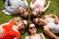 Group of smiling friends lying on grass outdoors Royalty Free Stock Photo