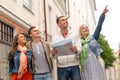 Group of smiling friends with map exploring city Royalty Free Stock Photo