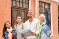 Group of smiling friends with map exploring city Royalty Free Stock Photo