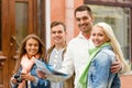 Group of smiling friends with map and photocamera