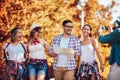 Smiling friends walking with backpacks in woods - adventure, travel, tourism, hike and people concept Royalty Free Stock Photo