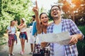 Smiling friends walking with backpacks in woods - adventure, travel, tourism, hike and people concept Royalty Free Stock Photo