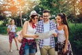 Smiling friends walking with backpacks in woods - adventure, travel, tourism, hike and people concept Royalty Free Stock Photo