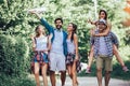 Smiling friends walking with backpacks in woods - adventure, travel, tourism, hike and people concept Royalty Free Stock Photo