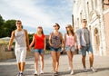 Group of smiling friends walking in city