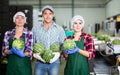 Group of smiling workers standing with watermelons in hands in sorting factory Royalty Free Stock Photo