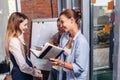 Group of smiling girlfriends laughing while studying and revising for exam in library Royalty Free Stock Photo