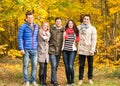 Group of smiling men and women in autumn park Royalty Free Stock Photo