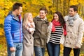 Group of smiling men and women in autumn park Royalty Free Stock Photo