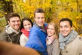 Group of smiling men and women in autumn park Royalty Free Stock Photo