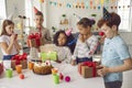 Group of smiling mixed race children with decorative whistles having birthday party Royalty Free Stock Photo